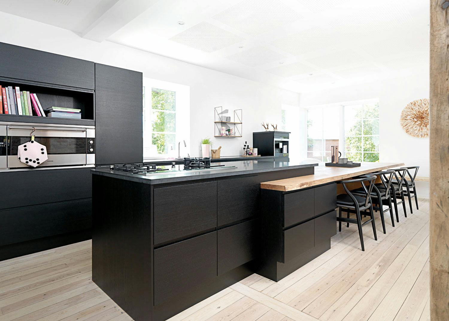9. Bryt opp en svart vegg med hyller Svart kjøkkeninnredning brytes fint opp med hyller og hvitevarer i stål. Vinduer uten gardiner slipper inn ekstra mye lys. Kjøkkeninnredning fra JKE design.